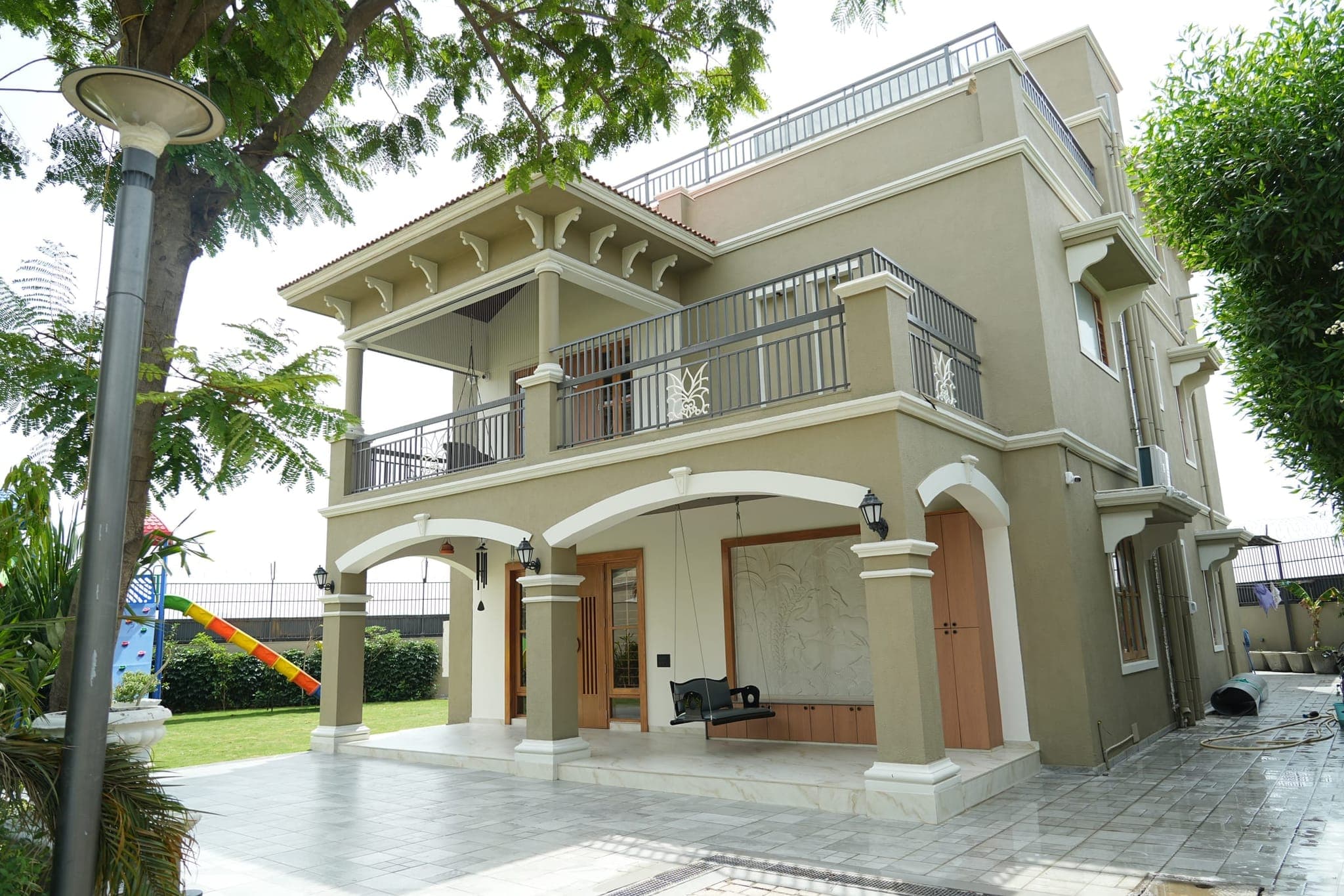 Exterior elevation of a luxury villa with arched openings and a first-floor balcony